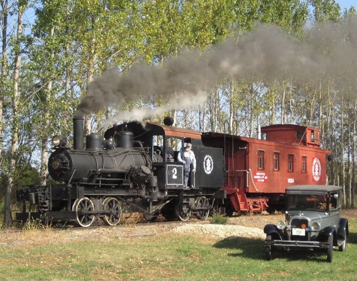 Silver Creek and Stephenson Railroad steam locomotive with caboose and antique automobile